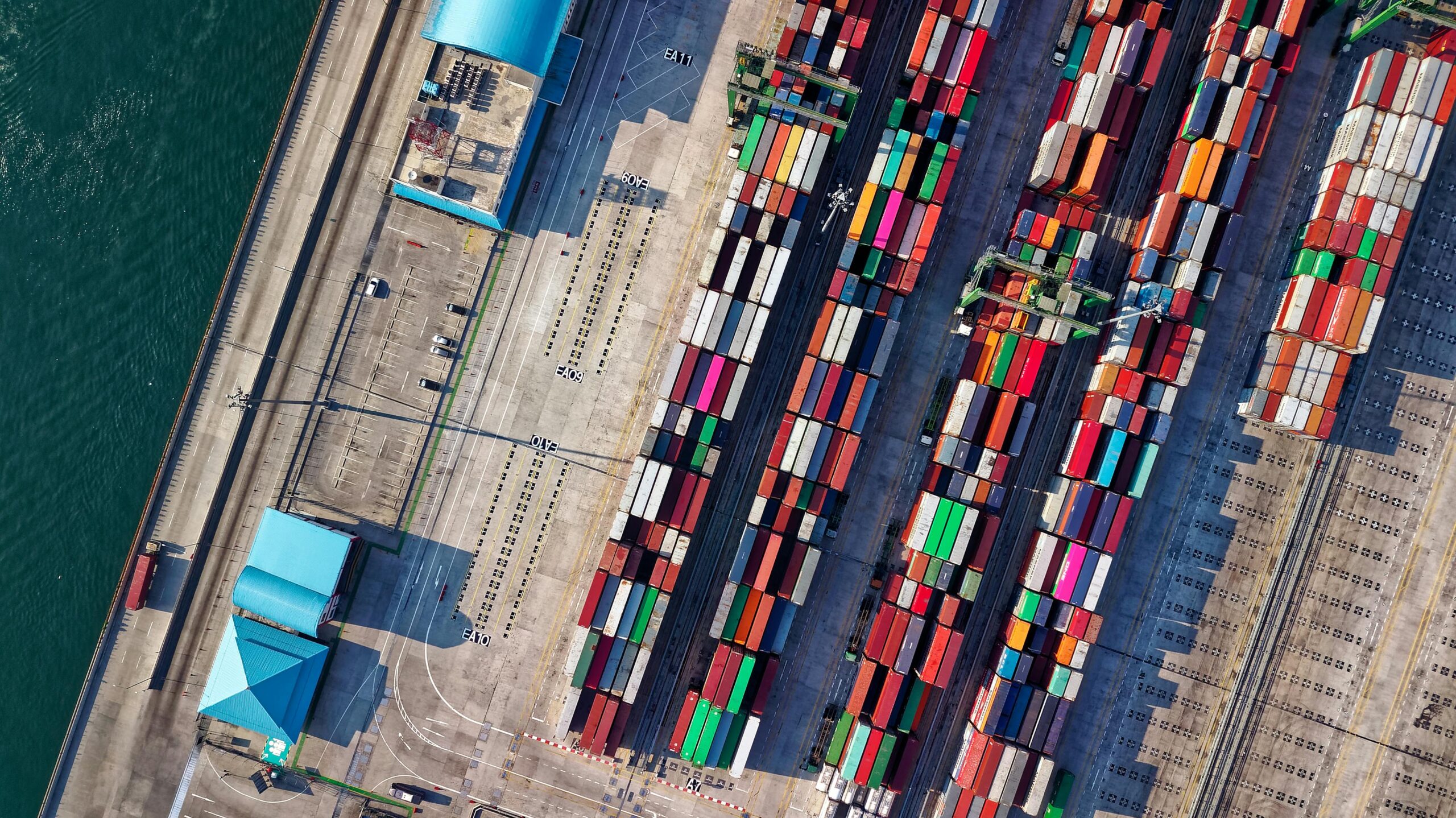 Top view of colorful shipping containers at a bustling port in Jakarta, Indonesia.