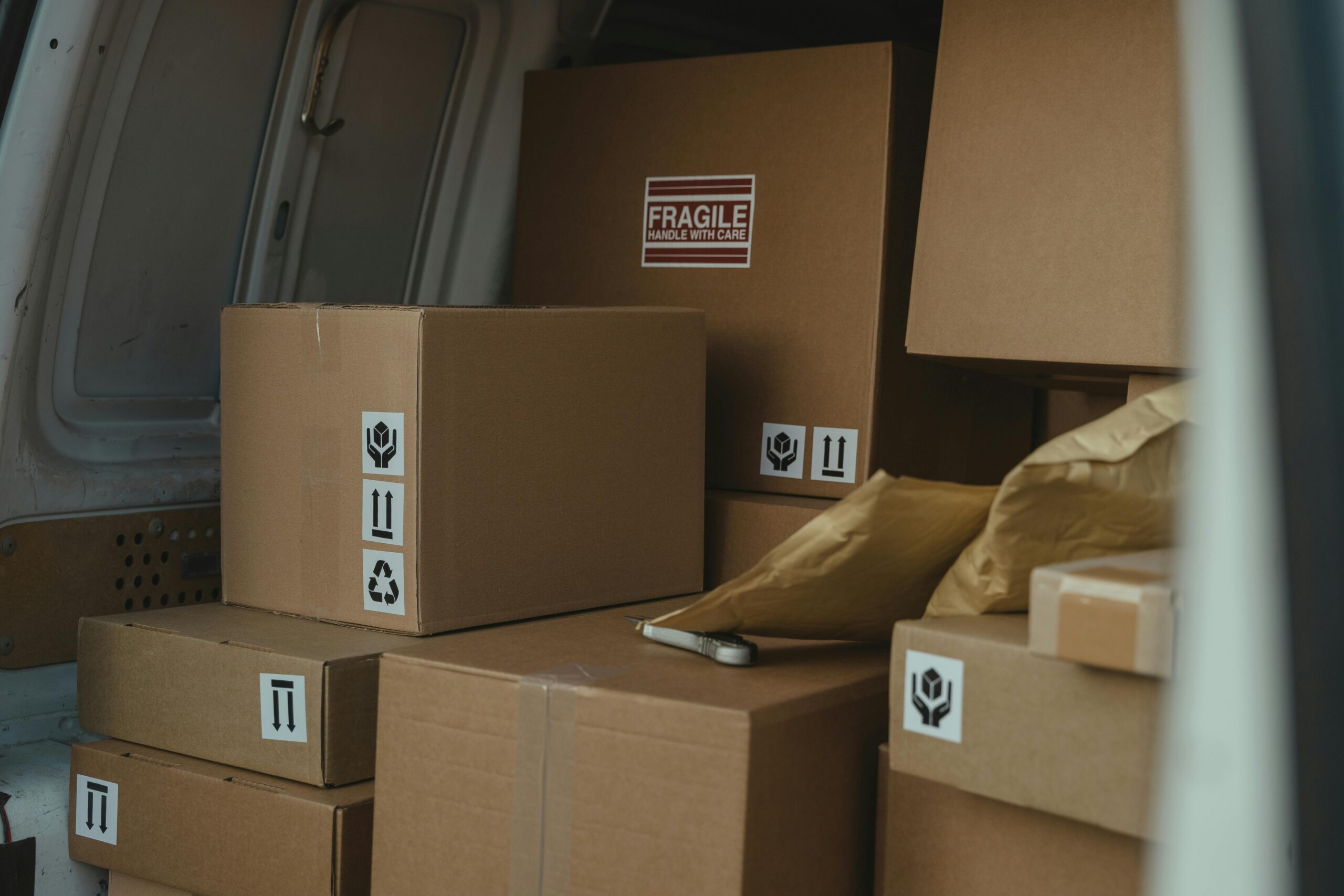 Neatly organized cardboard boxes inside a delivery van, ready for shipment.